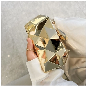 Detailed view of a gold geometric faceted acrylic evening clutch bag with metal chain