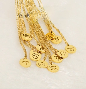 Détails macro de pendentifs zodiaque dorés en acier inoxydable avec gravures sur fourrure