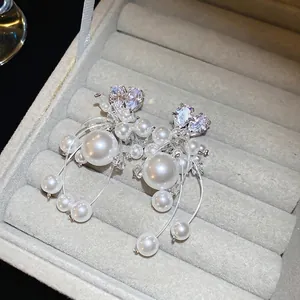 Eleganti orecchini a cuore con cristalli e perle su una scatola di gioielli in velluto