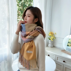 Detail shot of pashmina cashmere scarf with plaid pattern, tassels and fabric care label