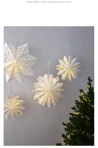 Macro detail of white paper snowflake lanterns with warm LED lighting for Nordic home decor