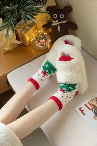 Chaussettes de Noël rouges et blanches avec chaussons en peluche dans un décor festif