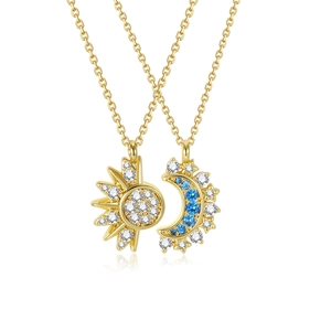 Detail of sun and moon necklaces with gold chains, white crystals and blue stones