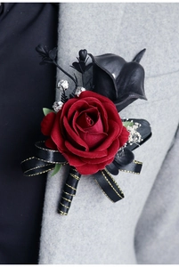 Détail d'une boutonnière rose rouge et calla noir sur un revers en laine grise