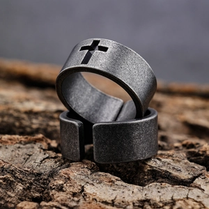 Vintage stainless steel biker rings set with cross cutout on rustic bark background