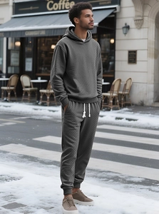 Detailed view of dark grey waffle knit hoodie set on a model in a winter street setting
