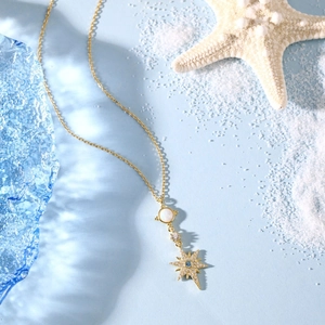 Macro shot of S925 silver necklace with white opal and star pendant on sea theme background