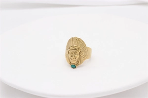 Dettaglio dell'anello maschera da capo indiano dorato con piume incise e pietra turchese