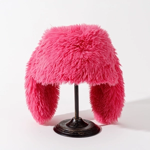 Detail of hot pink plush trapper hat with long faux fur on a vintage metal stand