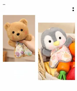 Close-up of cute plush bear and penguin dolls with floral fabric details and soft texture