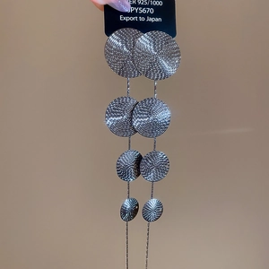 Close-up of S925 silver fringe earrings with layered spiral textured metal discs