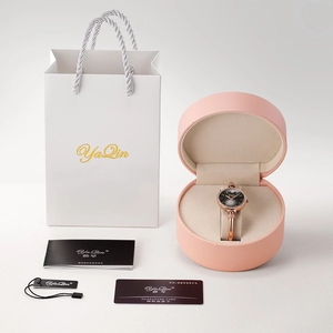 Dettaglio del set con orologio, portagioie rosa, borsa regalo e certificato di garanzia