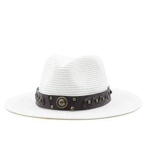 Detail of white straw fedora featuring a brown leather band and metallic studs