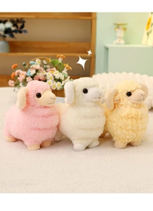 Three plush lamb dolls in pink, white, and yellow colors on a cozy soft surface
