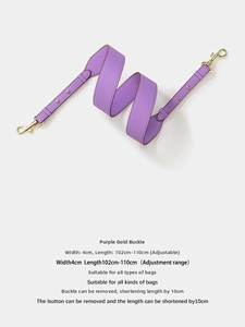 Detail of purple grained leather bag strap with golden rotating metal buckles