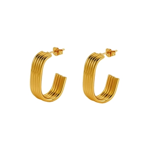 Dettaglio di orecchini a U placcati oro 18K con trama a scanalature e design minimalista