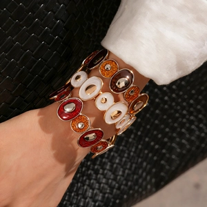 Détail d'un bracelet bohème en émail avec segments ovales colorés sur base dorée