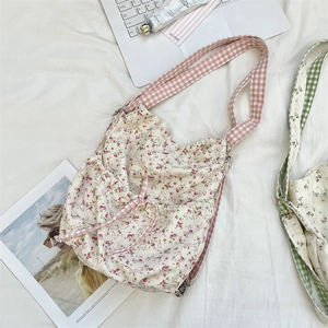 Floral canvas shoulder bag featuring pink checkered straps and a drawstring bow design