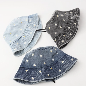 Denim bucket hats with daisy embroidery in light blue, dark grey, and medium blue wash
