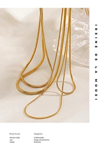 Close-up detail of layered gold snake bone chains showing flexible texture and metallic shine