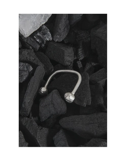 Artistic detail of S925 sterling silver open ring with irregular texture on black coal