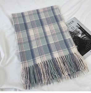 Close-up of blue and grey vintage plaid scarf featuring soft texture and tassel fringe