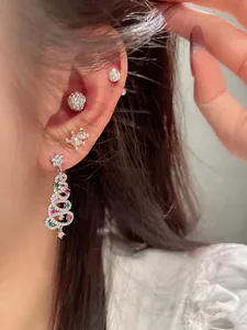 Detail of Christmas tree earrings set with multicolored zircon stones on female model