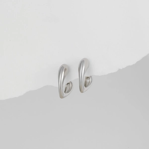 Nahaufnahme silberner Tropfenohrringe mit glattem Metallfinish und minimalistischem Design