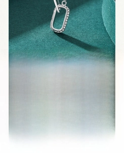 Macro shot of silver clavicle necklace featuring a hollow rectangular zircon pendant
