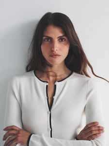 Gilet en maille blanc ajusté avec liserés noirs et boutons pour un look élégant français