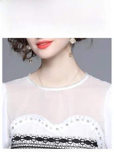 Detailed view of white chiffon top featuring delicate lace trim and shimmering sequins