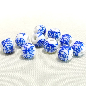 Macro shot of 10mm white ceramic beads with traditional blue Shou character patterns