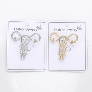 Detail of anatomical womb brooches in gold and silver with heart-shaped crystals