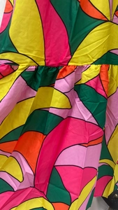 Detailed view of colorful geometric print and pleated waist on this summer maxi dress