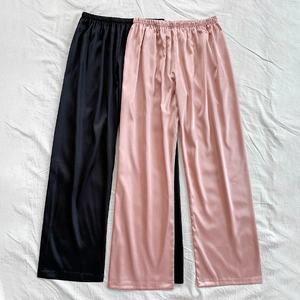 Loose silk-like wide leg lounge pants in black and pink with elegant satin finish