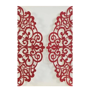 Detail of red glitter laser-cut invitation cover with elegant symmetric floral patterns