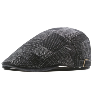 Detail view of denim newsboy cap with adjustable metal buckle and woven texture