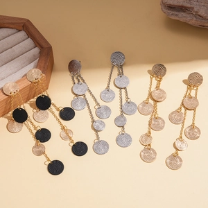 Detailed shot of three sets of tiered round sequin tassel earrings in gold and silver