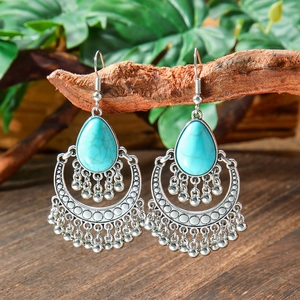 Bohemian vintage teardrop turquoise dangle earrings with silver beads on a wood branch