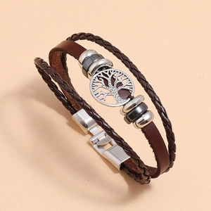 Detail of multi-layer leather bracelet with silver tree of life charm and metal beads