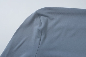 Detailed close-up of gray-blue ruched fabric texture and stitching on the summer dress