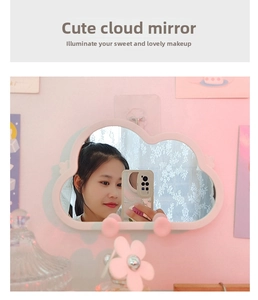 Detailed view of pink cloud-shaped makeup mirror with wall hook on a pink background