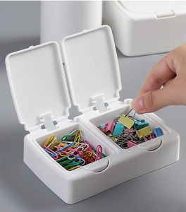 Macro shot of a white double-compartment organizer box with clips and paperclips inside