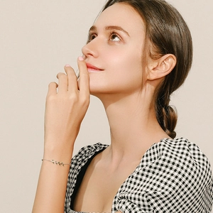 Elegant s925 silver leaf bracelet with gold finish worn by model in a minimalist style