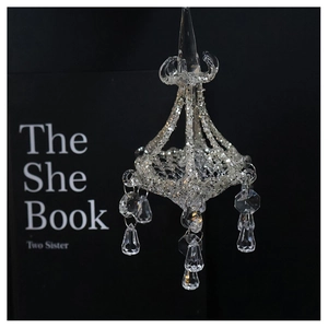 Detail of crystal glass chandelier ornament with glitter accents and teardrop pendants