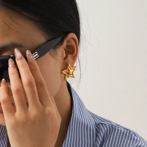 Elegant 18K gold plated stainless steel star stud earrings worn by a fashion model