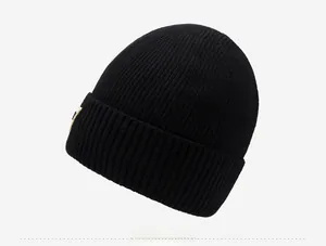 Close-up of black ribbed knit beanie showing fine texture and square side label