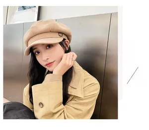 Macro detail of beige newsboy hat with metal buckle detail on a fashion model