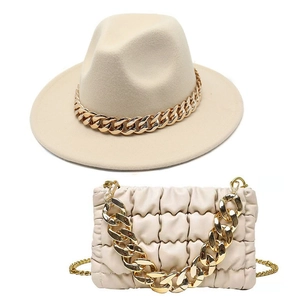 Close-up of beige felt fedora hat and quilted cloud bag with thick gold chain link straps
