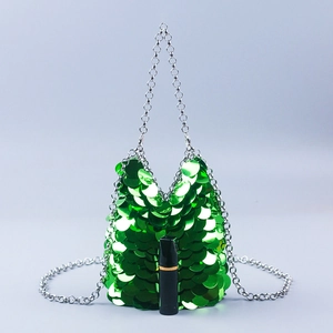 Detail of green sequin mini bag with silver chain and a lipstick for size reference